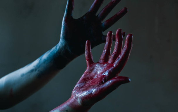 Cosplayer portrays executioner and killer showing hands stained with blood. Closeup. - Photo, Image