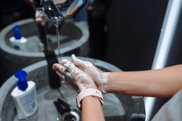コロナウイルスから守るために手を洗う女 - 写真・画像
