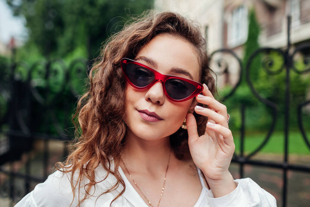 Стильные летние солнечные очки. Уличный портрет молодой модницы в аксессуарах в городском парке. Закрыть
 - Фото, изображение