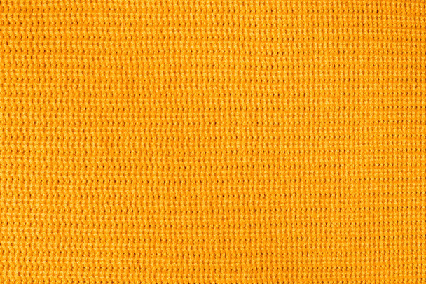 Orange textile background knitwear. Wool background, top view. Abstract fresh colorful yellow knitted pattern background texture. Orange knitted pattern of acrylic yarns, closeup. - Photo, image