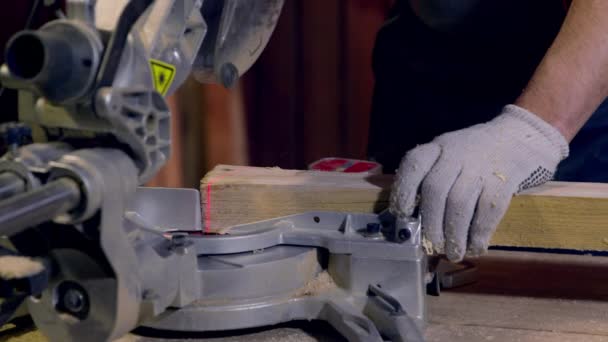 Carpintero utiliza vigas de madera de corte de sierra circular. Línea láser roja en blanco - Imágenes, Vídeo
