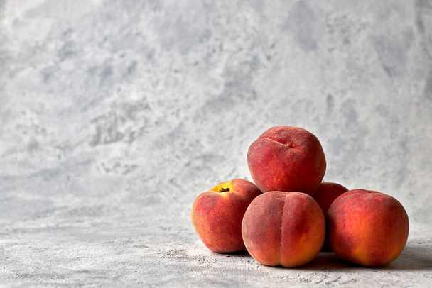 Пять спелых, сочных персиков на белом пятнистом фоне
 - Фото, изображение