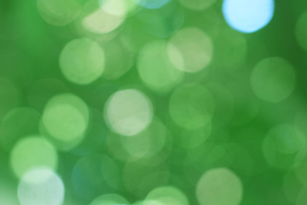 Abstract bokeh, natural green and blue background, beautifully blurred during the summer, which is a blue-green bokeh taken from the leaves on the tree and has a yellow-blue light - Foto, immagini