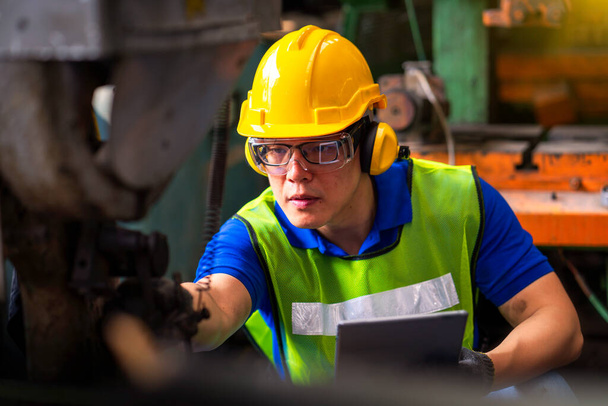 Technici a inženýři pracují na strojích v továrně. Asijský muž Strojní inženýr drží tablet a kontrolní zařízení v průmyslu. - Fotografie, Obrázek