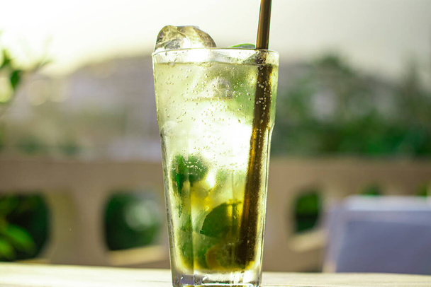 Delizioso cocktail alcolico mojito sul tavolo con sfondo paesaggio caffè. - Foto, immagini