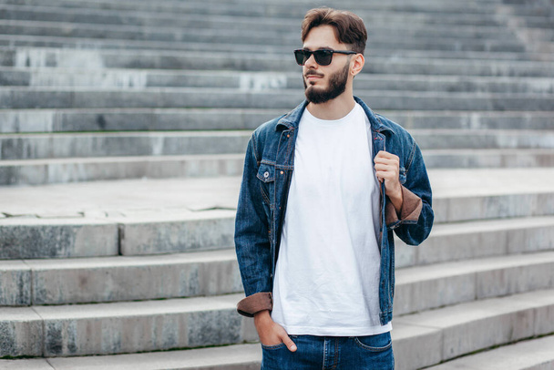 Mladý stylový muž s vousy v bílém tričku a brýlích. Fotografie z ulice - Fotografie, Obrázek