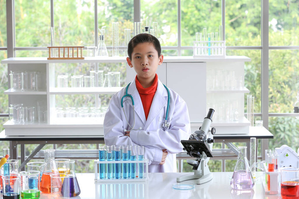 De jonge wetenschapper staat voor zijn eigen experiment in het lab. Jonge kinderen in het wetenschapslaboratorium bestuderen monsters. Test op virusdetectie. - Foto, afbeelding