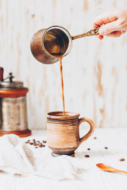 Coffee with milk is poured into a mug - Valokuva, kuva