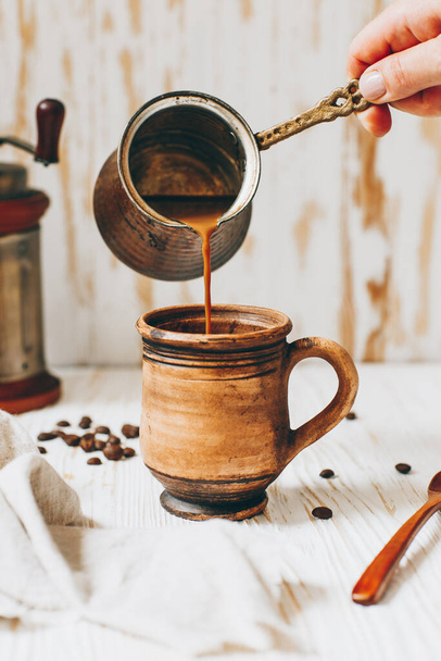 Coffee with milk is poured into a mug - Zdjęcie, obraz