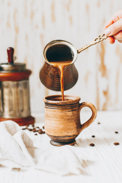 Coffee with milk is poured into a mug - Zdjęcie, obraz
