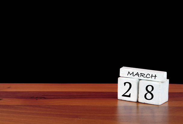 28 Μαρτίου ημερολογιακού μήνα. 28 ημέρες του μήνα. Ανακλαστικό ημερολόγιο σε ξύλινο πάτωμα με μαύρο φόντο - Φωτογραφία, εικόνα