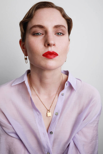 Headshot of gorgeous brunette woman wearing red lips and lavender shirt. - 写真・画像