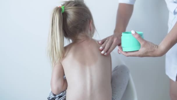 Der Arzt reibt die Körpercreme in den sonnenverbrannten Rücken - Filmmaterial, Video