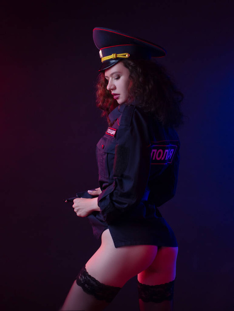 γυμνό κορίτσι με αστυνομική στολή με όπλο. Αγγλική μετάφραση της αστυνομίας - Φωτογραφία, εικόνα