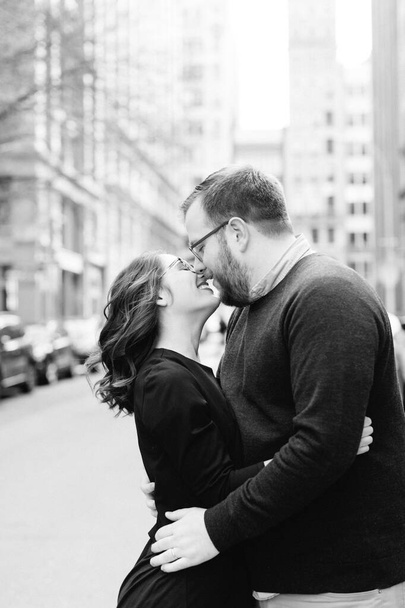 Чоловік і жінка тримають руки і цілуються в міській обстановці
 - Фото, зображення