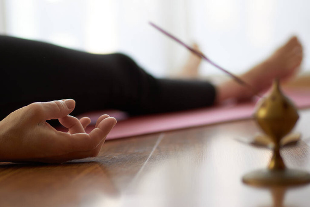 mujer practicando yoga, acostada en postura de yoga nidra, ejercicio en Shavasana, ejercicios, trabajo, descanso después de la práctica, mano femenina. concepto de estilo de vida saludable
 - Foto, Imagen