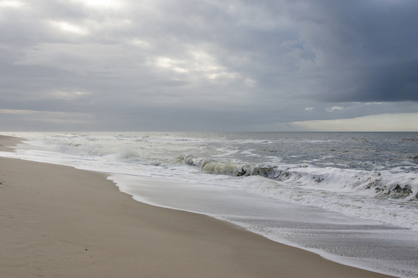 Playa con nubes de lluvia oscura
 - Foto, Imagen