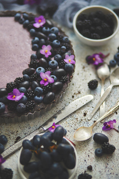 Homemade blackberry tart. Sweet pie with blackberrym blueberry and grapes on stone table - 写真・画像