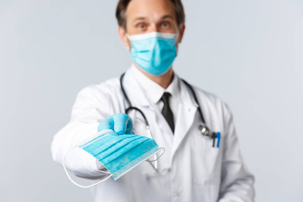 Covid-19, prevence viru, zdravotnických pracovníků a koncepce očkování. Přátelský lékař dát pacienta lékařskou masku, aby zůstali zdraví během pandemie koronaviru. Lékařské podání PPE - Fotografie, Obrázek
