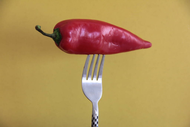 červená paprika ve vidličce na žlutém pozadí - Fotografie, Obrázek