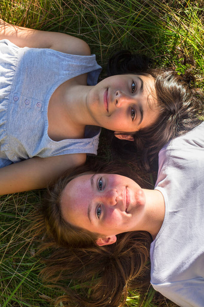 Visão superior de duas jovens deitadas na grama
. - Foto, Imagem