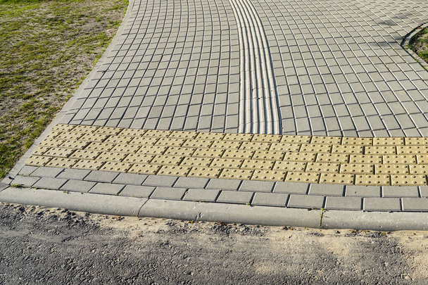 neuer gepflasterter Gehweg mit Richtlinien für sehbehinderte Menschen, sehbehinderte Menschen zu Fuß Straßenschilder - Foto, Bild