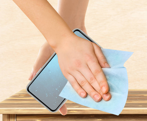 mains avec lingette humide nettoyer l'écran de téléphone smartphone - Photo, image