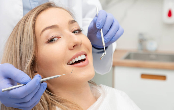Woman having teeth examined at dentists. Teeth whitening, dental care concept - Zdjęcie, obraz