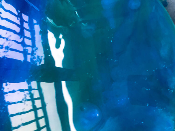abstrakcyjne tło z wizerunkiem tematu morskiego, powierzchnia wody przy użyciu płynnej techniki epoksydowej sztuki. ocean na zdjęciu z odbiciem konstrukcji żelaza. oślepiające światło na tle - Zdjęcie, obraz