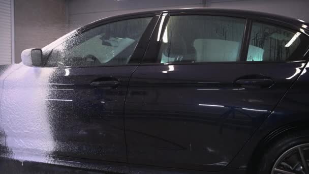 Proces mytí aut. Pěnící čisticí prostředky kryjí bok auta, čistí ho od špíny a prachu. - Záběry, video