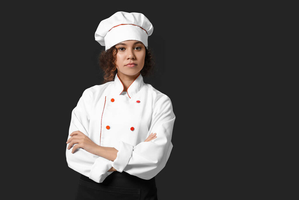 Vrouwelijke Afro-Amerikaanse chef-kok op donkere achtergrond - Foto, afbeelding