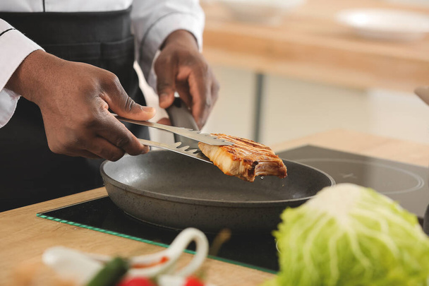 Afrikkalainen-amerikkalainen keittiömestari ruoanlaitto, lähikuva - Valokuva, kuva