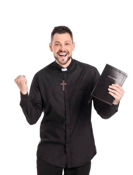 Gelukkig priester met bijbel op witte achtergrond - Foto, afbeelding