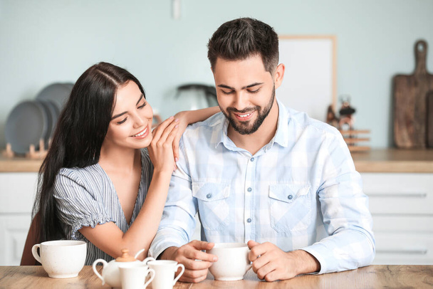 Happy young couple drinking tea at home - Photo, image