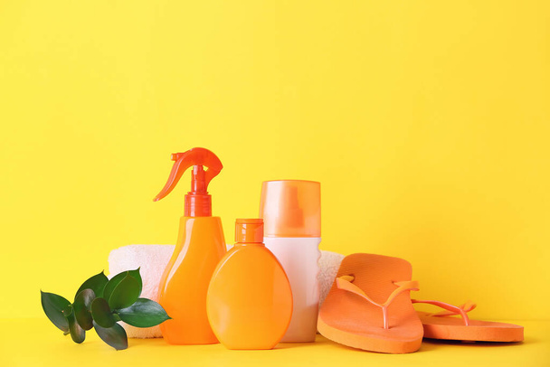Beach accessories with sunscreen cream on color background - 写真・画像