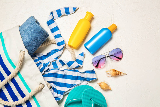 Strand accessoires met zonnebrandcrème op witte achtergrond - Foto, afbeelding