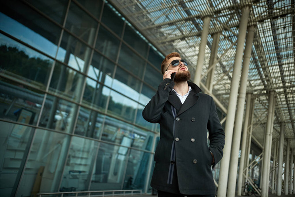 Urban business man in sunglasses talking smart phone traveling walking outside - Fotoğraf, Görsel