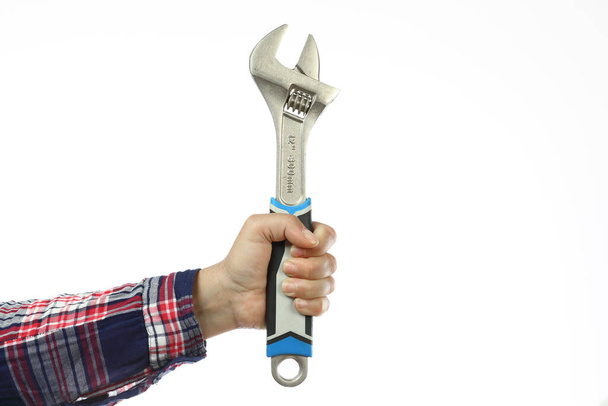DIY, hand and arm of a handyman with a checkered shirt holding an adjustable wrench on a white background, iillustration of the concept made by yourself or home made, DIY course - 写真・画像