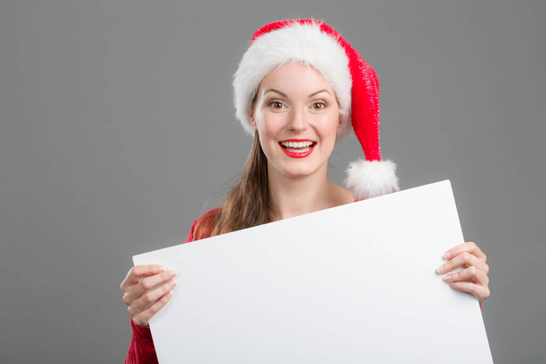 junge Frau mit Weihnachtsmann-Hut und Werbetafel  - Foto, Bild
