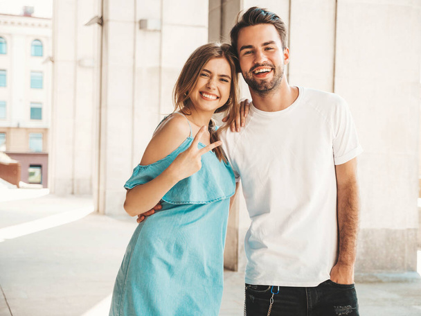 Portrait of smiling beautiful girl and her handsome boyfriend.Woman in casual summer jeans dress.Happy cheerful family.Female having fun.Couple posing on the street background - Foto, imagen
