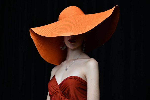 krásná dívka v burgundském klobouku a v burgundské večerní šaty pózují na černém pozadí - Fotografie, Obrázek
