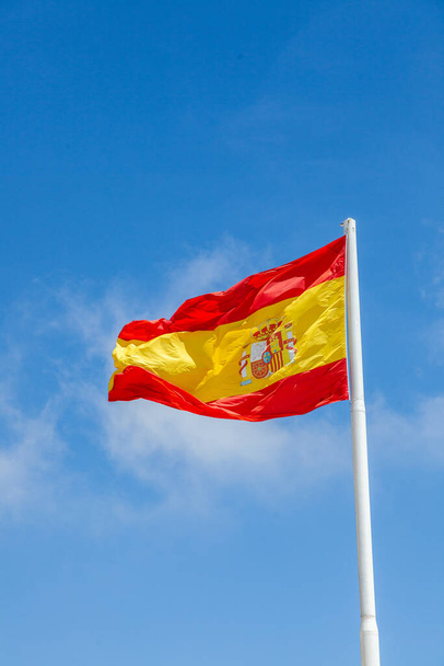 La bandera de España, tal como se define en la Constitución Española de 1978, consta de tres franjas horizontales: roja, amarilla y roja, siendo la franja amarilla el doble del tamaño de cada franja roja. Tradicionalmente, la franja media fue definida por el más ar - Foto, imagen