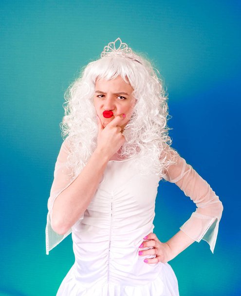Foto de mulher chateada com lábios vermelhos vestindo peruca encaracolada branca olhando para a câmera com raiva isolada sobre fundo azul
 - Foto, Imagem