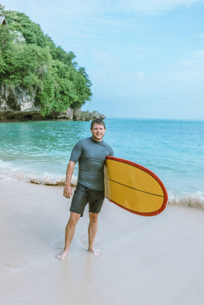 Man with surfboard on the beach. - Фото, зображення