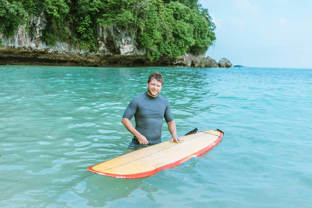 hombre con tabla de surf en la playa. - Foto, Imagen