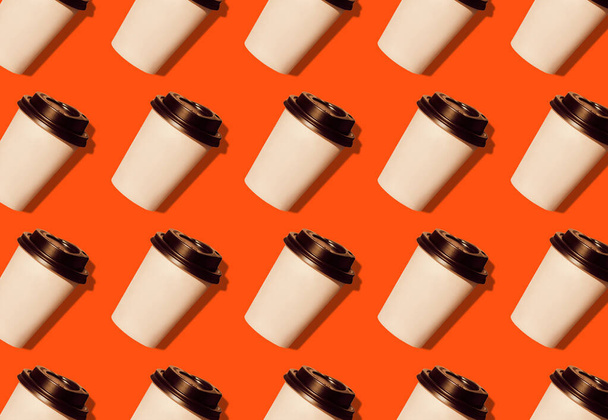 Coffee to go regular pattern made of photo on a lush lava background. Kraft paper cups with black lids and natural bright sun shadows. Lifestyle take away hot drinks concept. Trendy flatlay, top view. - Photo, Image