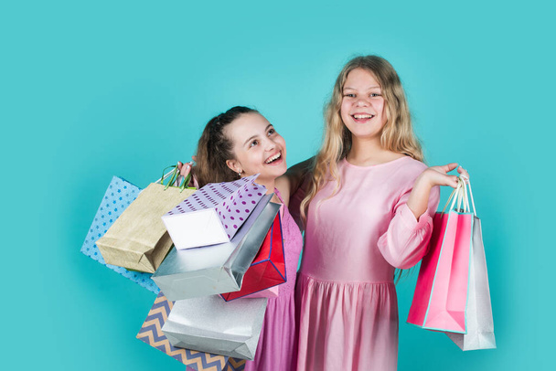 Nice purchase. big sale. teen girl hold paper bags. buy gifts and presents for holiday. shopaholic kids with purchase packages. happy children go shopping. black friday concept. kids on cyber monday - Foto, Imagen
