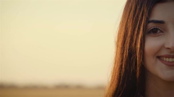 Fiatal mosolygós nő portréja naplementekor szállás címével vagy leírásával - Felvétel, videó
