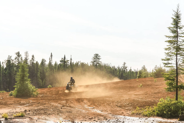 Hombre conduciendo ATV quad en terreno arenoso con alta velocidad
. - Foto, imagen