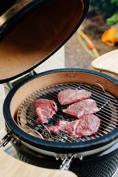 Marbled beef steak. Beef steaks on a wooden board in the sun. Nearby is butter and spices. The process of making steaks on the grill. Rib eye steak. - 写真・画像